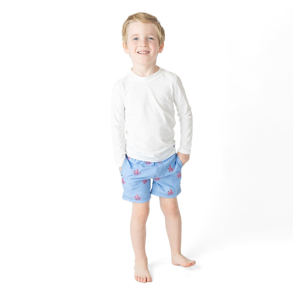 Boys Octopus Icon swim trunks on model showing fit and above-the-knee length.