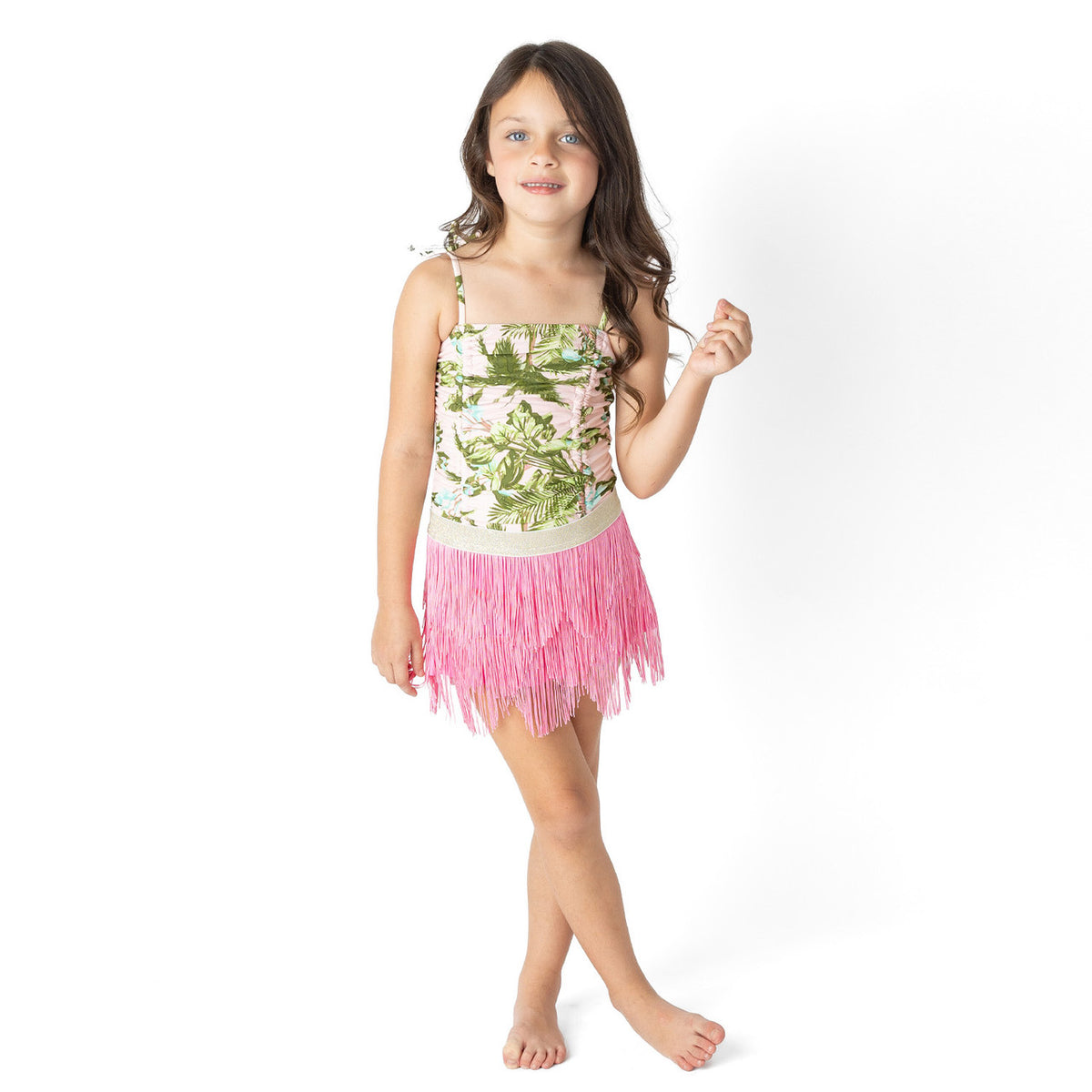 Girls tropical print one piece swimsuit with pink fringe skirt on model showing fit.