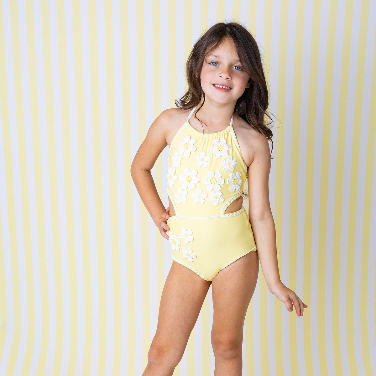 Girls Butter Yellow Daisy one piece swimsuit on model showing front fit.
