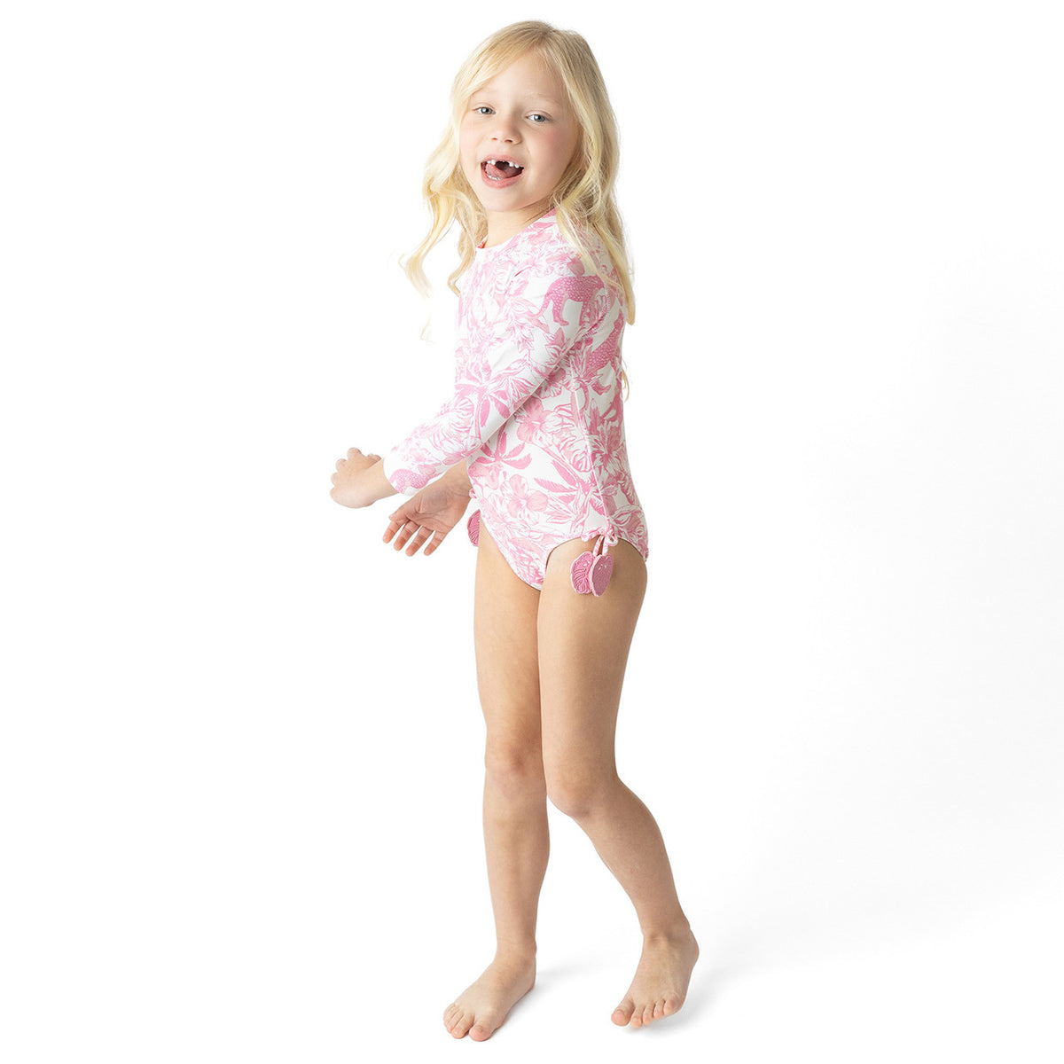 Side view of Pink Paradise girls long sleeve one piece swimsuit on model.