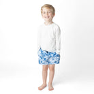 Shade Critters Denim Paradise trunks with white boys rashguard that is shown on toddler kids swimsuite with tropical blue print and elastic waistband.