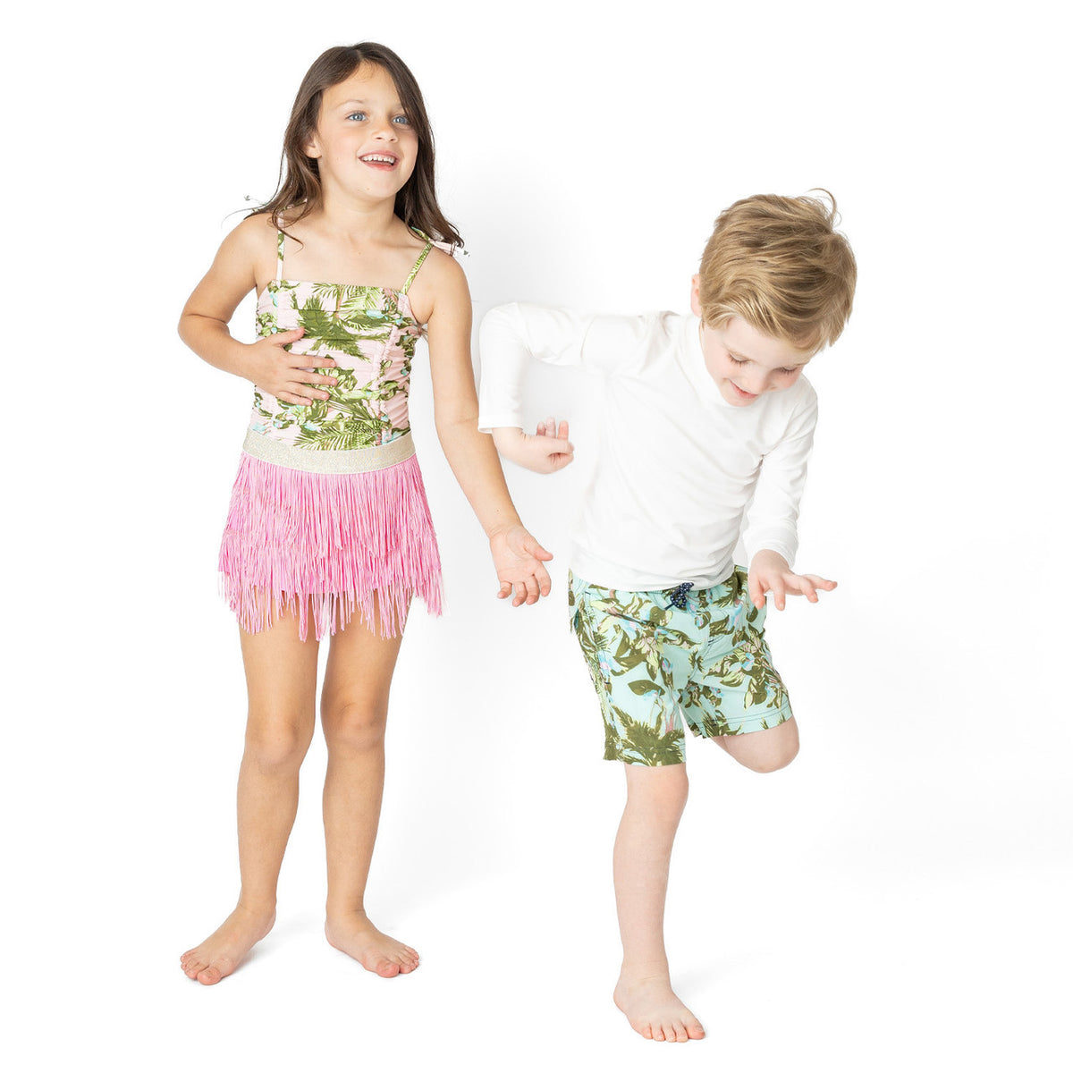 Boys Mint Tropics swim trunks styled in a coordinated summer sibling look.