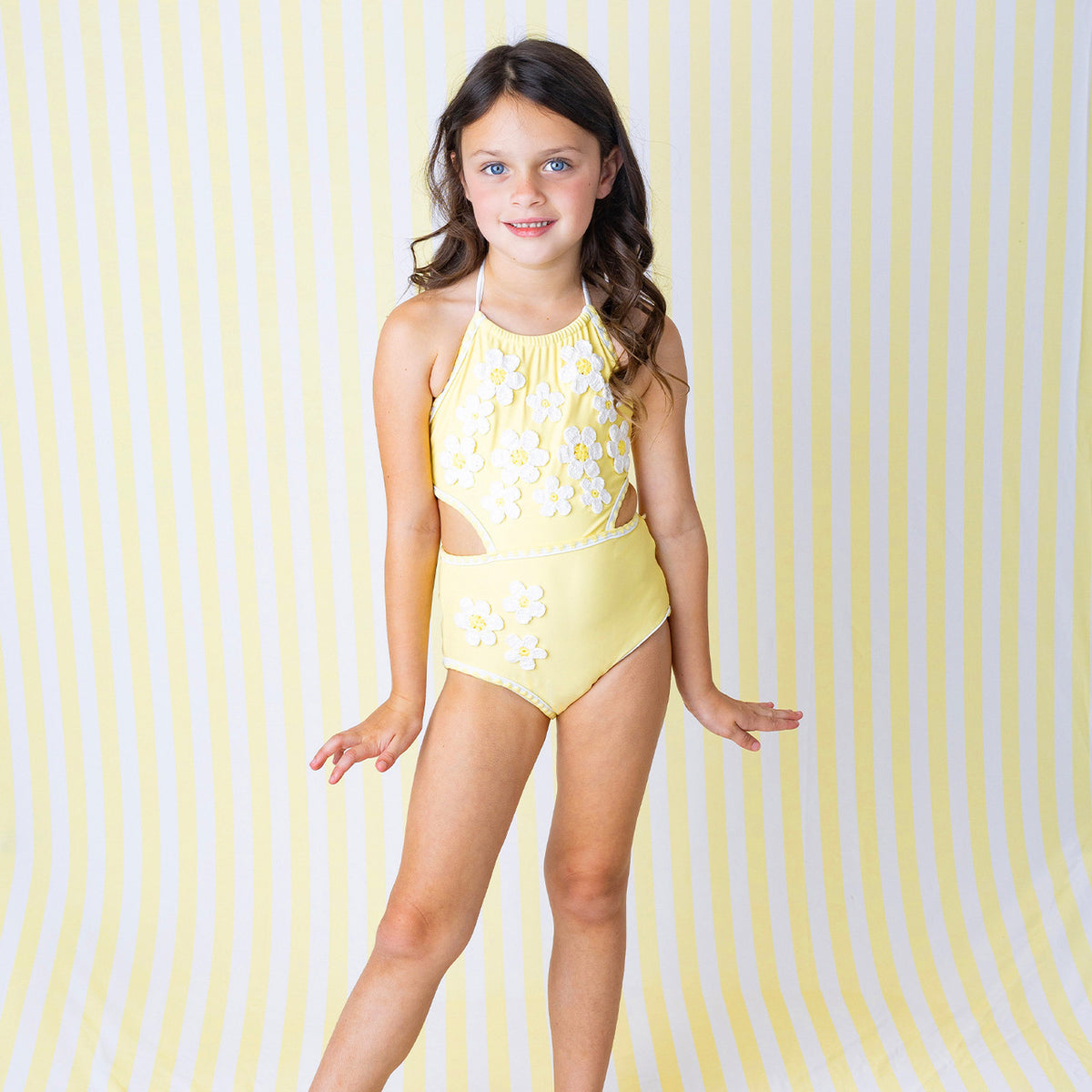 Side view of Butter Yellow Daisy girls one piece swimsuit on model.