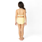 Back view of Butter Yellow Daisy girls one piece swimsuit on model.