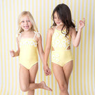 Girls wearing Butter Yellow Daisy one piece swimsuits.