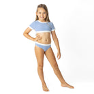 Girls cobalt stripe two piece swimsuit with short sleeve cropped top and matching bottoms, stylish kids swimwear shown on model.