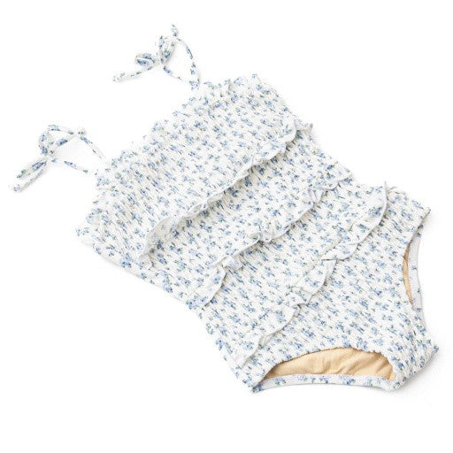 Angled view of Cottage Floral Blue girls one piece highlighting smocked texture and floral detail.