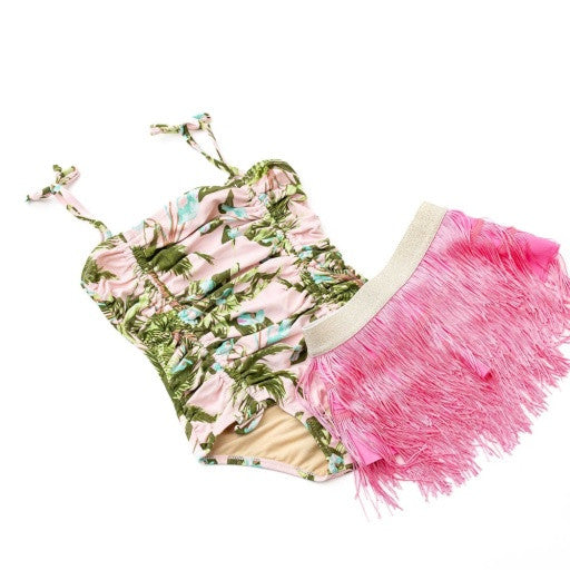 Close-up of girls tropical print one piece swimsuit highlighting ruching and pink fringe detail.