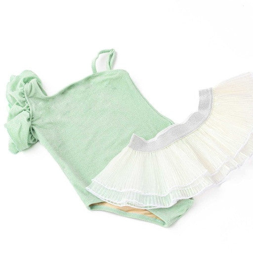 Highlighing the front of the Shimmer Mint one-shoulder suit by Shade Critters, with the oversized shoulder ruffles and soft metallic sparkle clearly visible. The pleated tutu skirt is arranged to showcase its full volume.