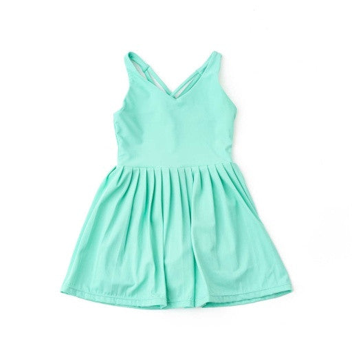 Shade Critters Green Girls Pleated Active Dress  full front view showing the smooth bodice, crisscross straps, and pleated skirt.